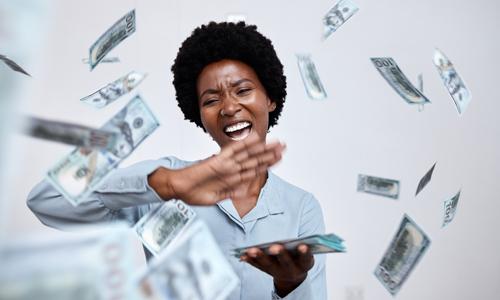 Woman smiling and making it rain money after making big life changes.