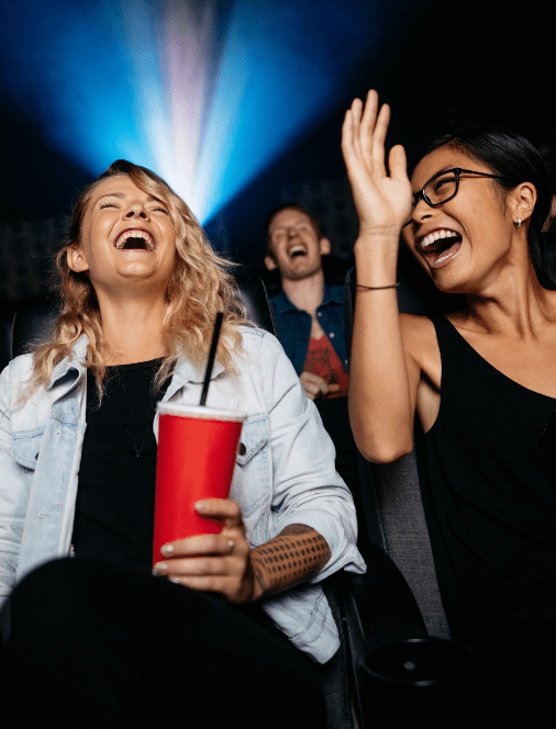 Two friends enjoy a night at the movies using Quorum's Member Discount Program.