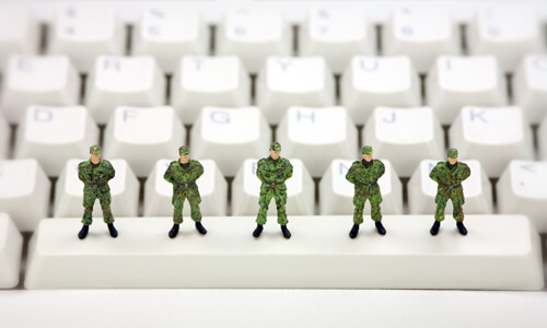 Toy soldiers standing on keyboard, illustrating ways to stop online identity theft.