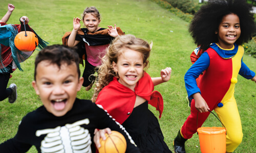 Young kids running in Halloween costumes.