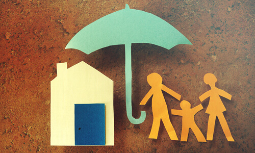 Paper cutouts of home, family and umbrella, illustrating homeowners insurance.