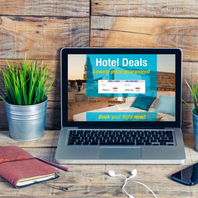 Laptop on desk with "Hotel Deals" displayed on screen.