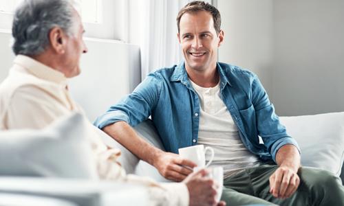 Man speaking with elderly father about finances.