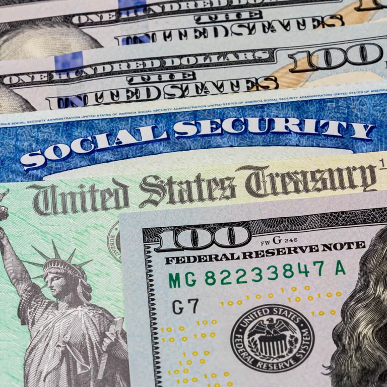 A photo of stacked U.S. currency including a social security card