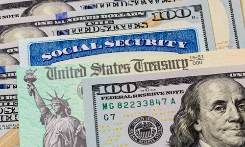A photo of stacked U.S. currency including a social security card