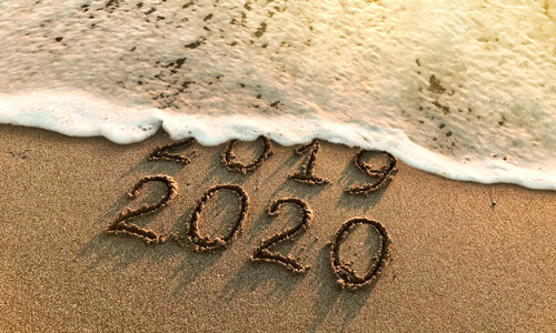 Beach shoreline - tide erasing "2019" and leaving the words "2020."