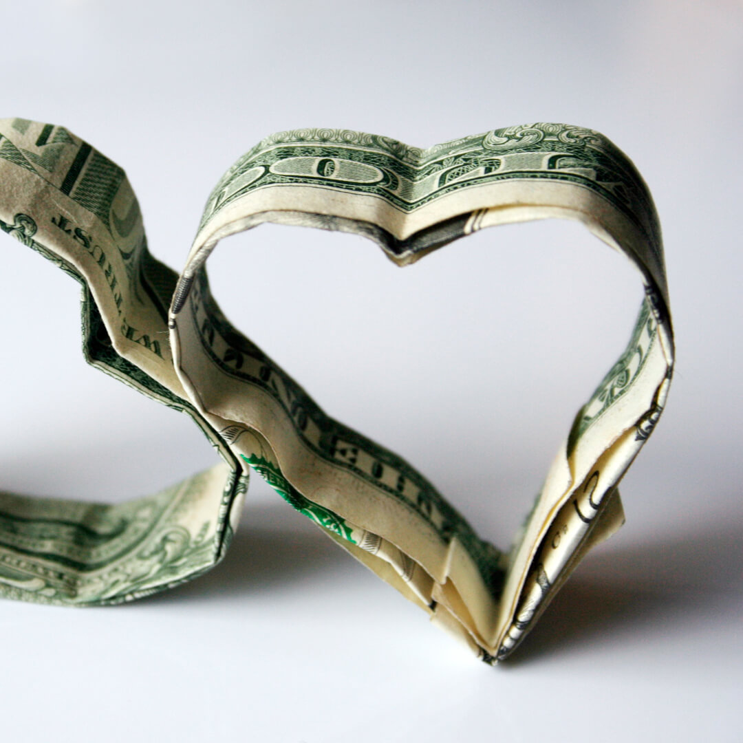 Dollar bills folded in the shape of two hearts.