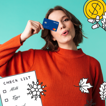 Cheerful woman in red sweater holding her Quorum Debit Mastercard in front of her.