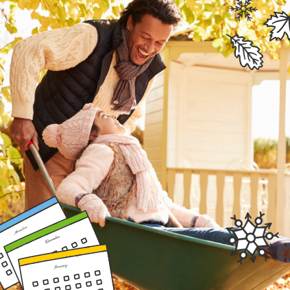 Father and his child wearing sweaters, smiling and playing outside with a wheelbarrow.