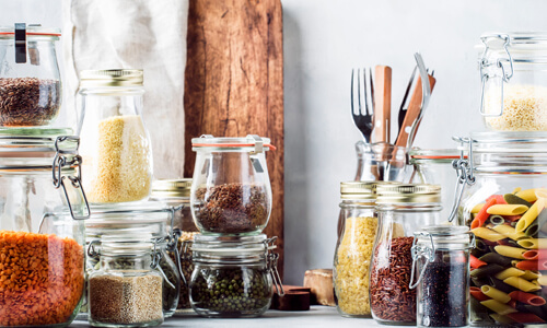Various pantry items in glass jars, like dried pasta and lentils.