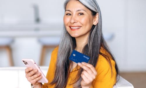 A woman smiles as she uses her Quorum Debit MasterCard to make secure purchases.