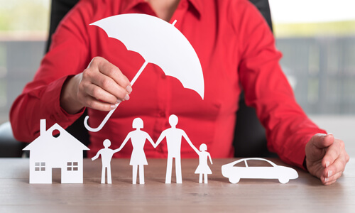 Umbrella Insurance - paper cutouts of umbrella shielding a home, family, and car.