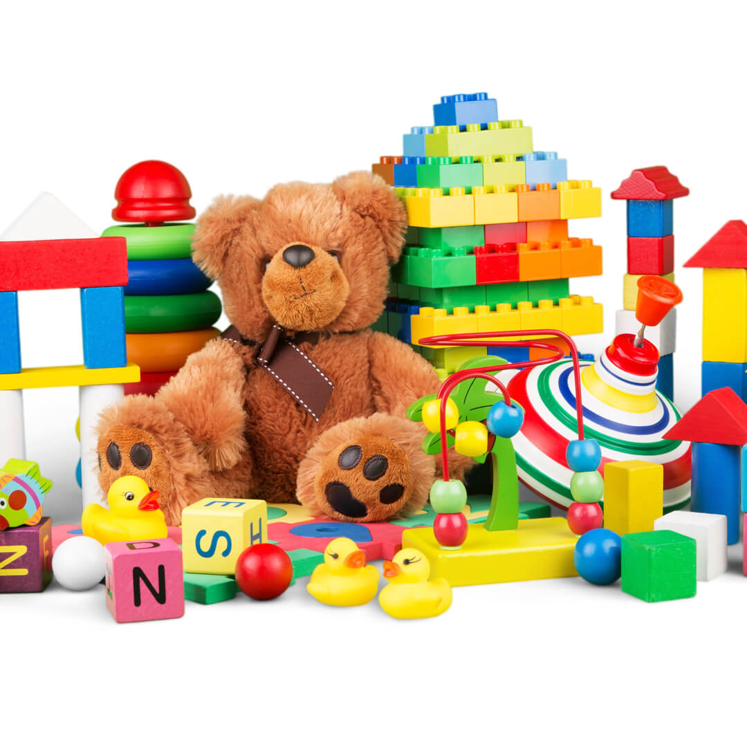 Childrens toys (teddy bear, brightly colored blocks and rings) against a white background.