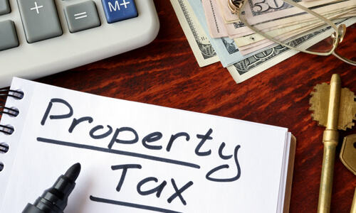 "Property tax" written in a notebook and calculator.