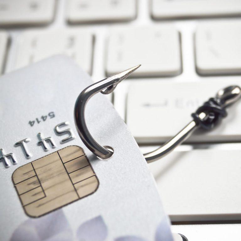 A fishing hook caught to a credit card, illustrating credit card fraud.