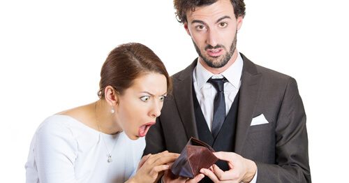 Couple who quit their jobs staring in horror at an empty wallet.