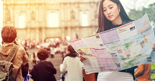 Young woman traveling in Rome, holding a map.