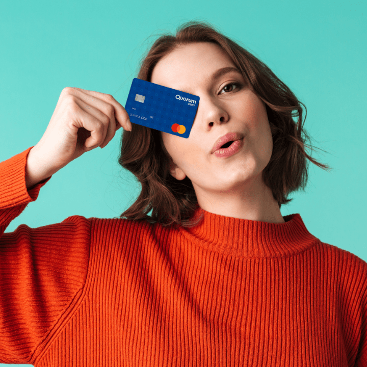 Woman holding a debit card in front of her face.
