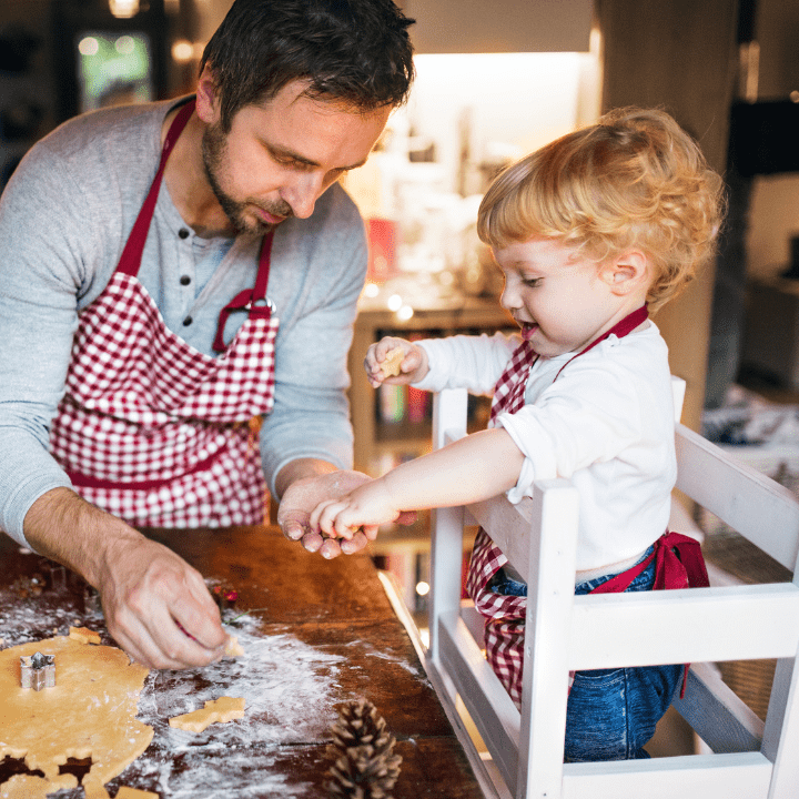 A dad bakes holiday cookies with his child.
