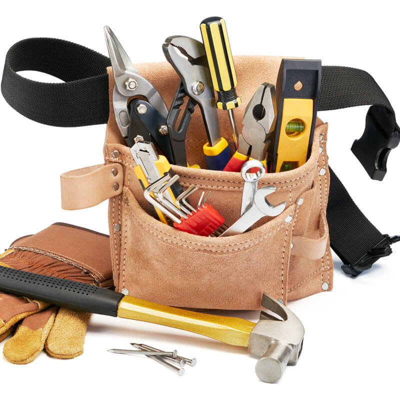 A variety of home improvement tools with tool belt on white background.