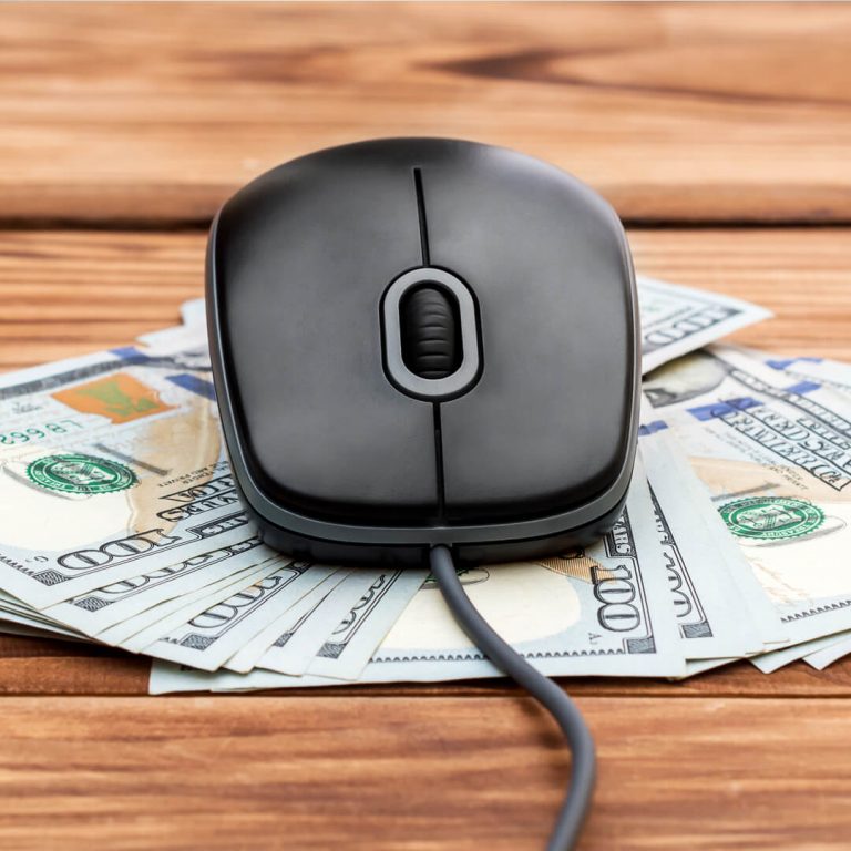 A computer mouse with hundred dollar bills underneath, illustrating the concept of wire transfers.